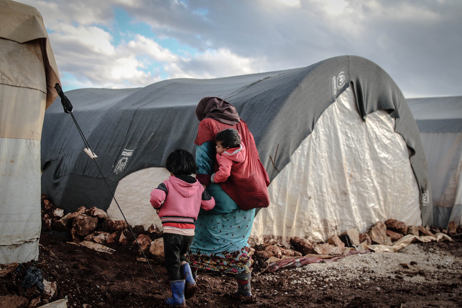 woman with kids walking on mud