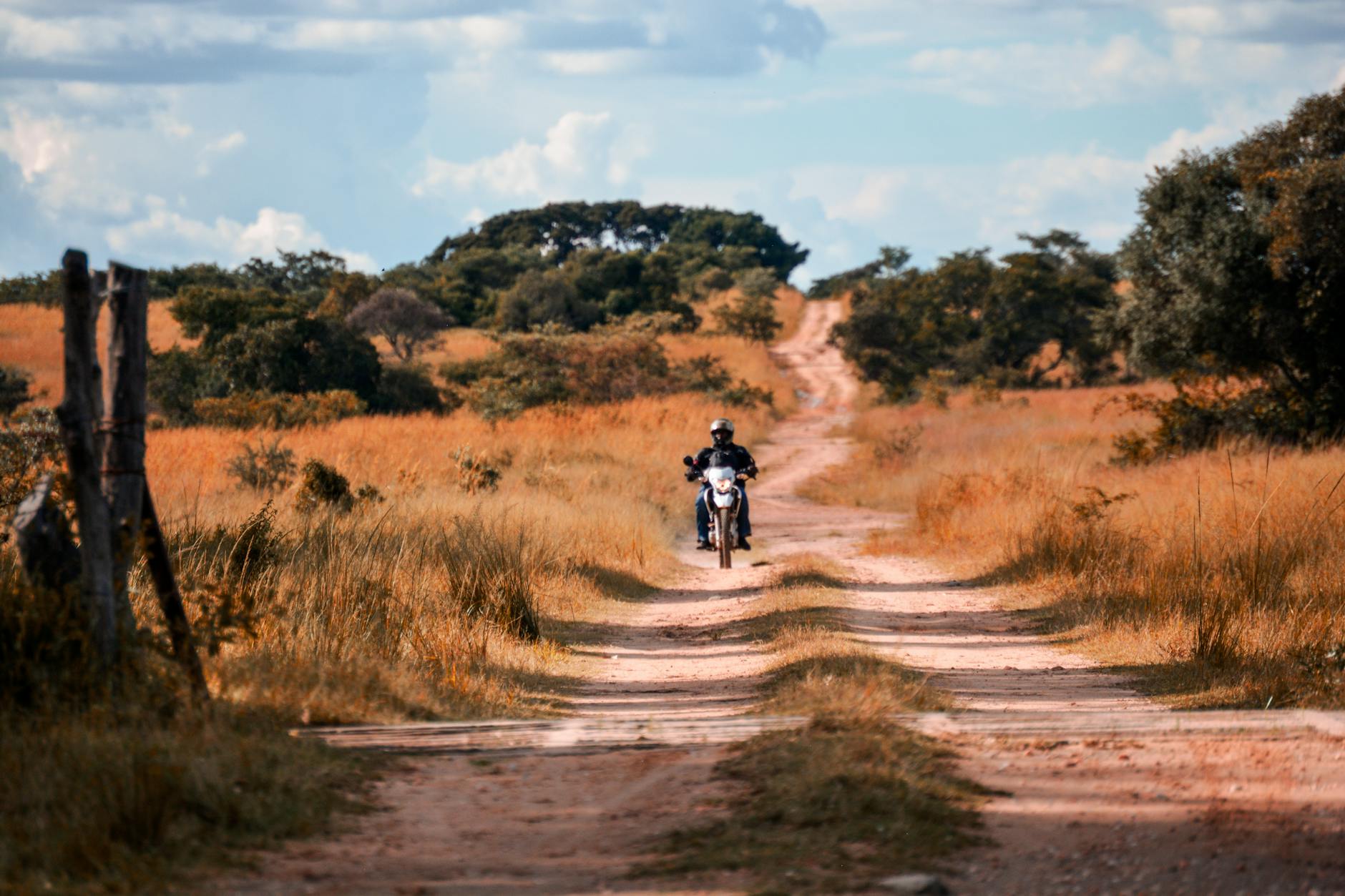 motorcyclist riding on a dirt road in the wilderness